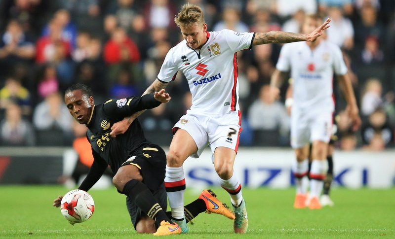 18 August 2015 - Sky Bet Championship - MK Dons v Bolton Wanderers - Carl Baker of MK Dons tangles with Neil Danns of Bolton Wanderers - Photo: Marc Atkins / Offside.